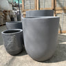 Fiber Pot Aura Grey Lifetime Warranty in the UAE. Metal pipes stacked outdoors on a concrete surface