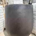 Long Lifetime Warranty Fiber Pot – Available in White, Yellow, Beige & Grey, UAE. Close-up of a black rubber hose on a concrete surface with white pipes in the background. 