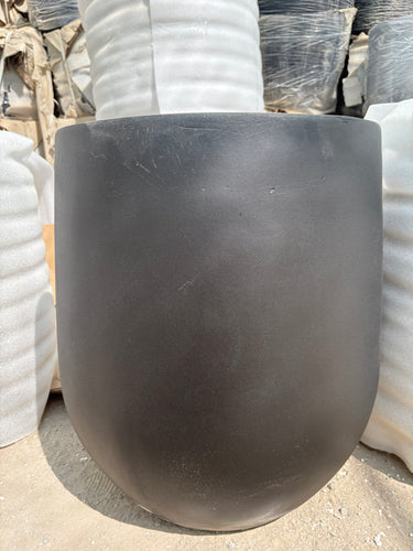 Long Lifetime Warranty Fiber Pot – Available in White, Yellow, Beige & Grey, UAE. Close-up of a black rubber hose on a concrete surface with white pipes in the background. 