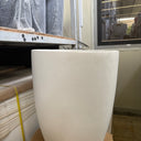 White Arco Fiber Pot with Matte Finish and Lifetime Warranty, UAE. White cylindrical object on a construction site with tools and materials in the background